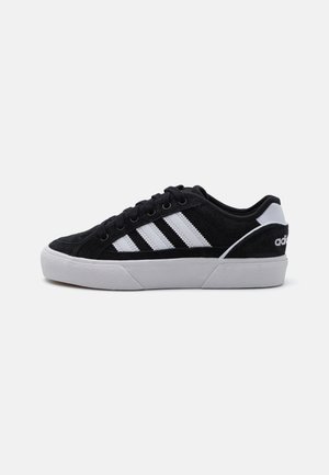 Sneaker in suede nero con design a tre strisce bianche, suola in gomma bianca e accenti neri. Caratterizzato da lacci tondi e colletto imbottito.