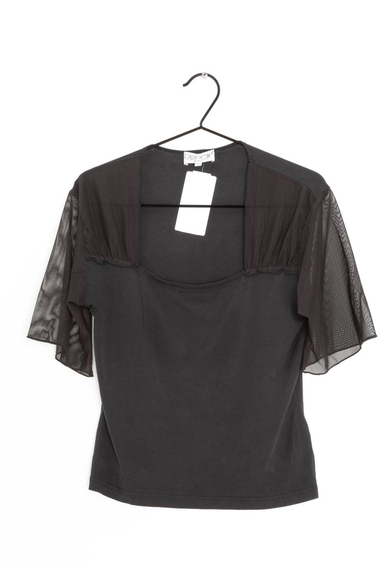 Svart blus med korta genomskinliga nätärmar, fyrkantig halsringning och en kropp av enfärgad tyg. Hänger från en svart krok med en storlekslapp fäst.