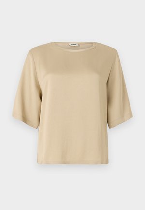 T-shirt in cotone beige con scollatura rotonda, maniche corte e vestibilità rilassata. Texture liscia e nessun motivo o decorazione visibile.