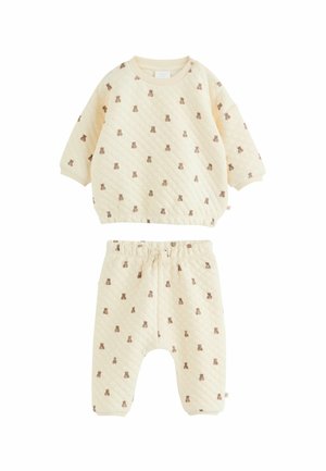 Quiltet to-dels babytøj i creme, med et mønster af små brune krammedyr. Toppen har en rund hals; bukser med elastisk talje.