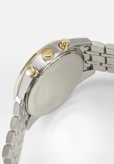 Montre en acier inoxydable argentée et dorée, avec un boîtier rond, une couronne texturée et des poussoirs chronographe, dotée d'un bracelet à maillons.