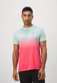 Treningst-skjorte med korte ermer i lyseblå og rosa gradient, med et teksturert mønster og en liten logo på brystet.