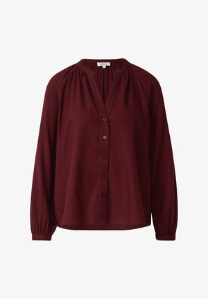 Burgundia pikkade varrukatega pluus, millel on ees nööbitav eesmine osa, õlgadel kergelt kätitud detail ning ümar kujuga alläär. Pehme kangas ribidega mansettidega.