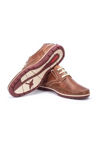 Zapatos de cuero marrón con cordones blancos, puntera redonda y costuras detalladas. Suela de goma con un acento rojo y patrones de agarre flexibles.