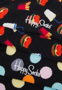 Schwarze Socken mit bunten, lebensmittelspezifischen Mustern, darunter Burger, Pommes und Getränke, verziert mit Punkten und "Happy Socks"-Markenlogo.