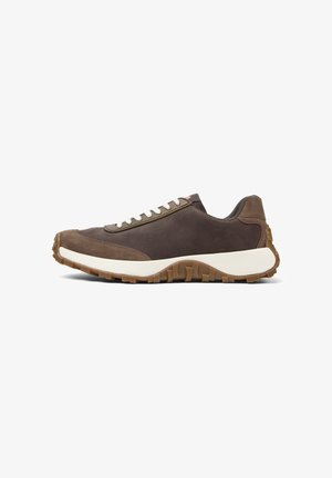 Dark brown sneaker with white laces, featuring a chunky sole and smooth fabric. Side view highlights the shoe's design and texture.