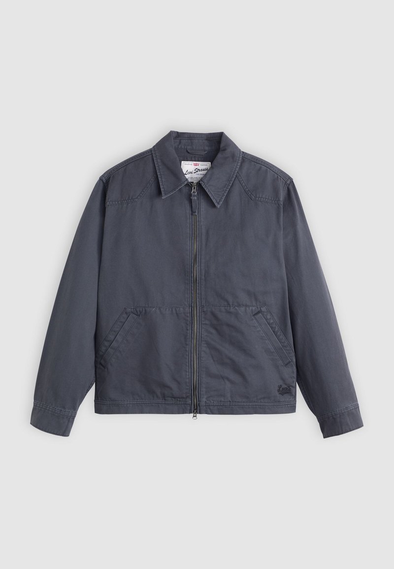 Dunkelgrau Jacke mit durchgehendem Reißverschluss, spitzem Kragen, zwei Seitentaschen und feinen Nähten. Hergestellt aus einem glatten Stoff.
