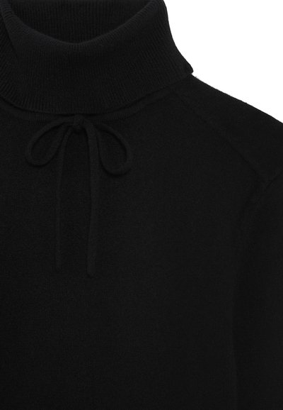 Suéter negro de cuello alto de punto con una silueta ajustada, que presenta un detalle de lazo en el cuello y puños acanalados. Textura suave, sin estampados.