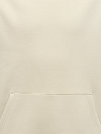 Beige Stoff Nahaufnahme zeigt die vordere Kängurutasche mit sichtbaren Nahtdetails an einem Sweatshirt oder Hoodie.