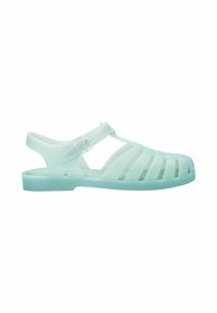 Zielone przezroczyste sandały z żelatyny z paskowym wzorem, regulowanym paskiem na kostkę oraz płaską podeszwą i otwartym palcem.