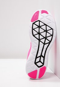 Sole di scarpa sportiva rosa con una base bianca, motivo di trazione nera e accenti testurizzati rosa. Design esagonali e a forma di diamante in evidenza.