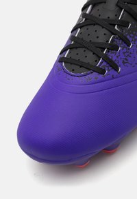 Purple soccer cleat featuring a textured synthetic upper, black laces, and a colorful splatter design near the toe, with pink accents on the sole.