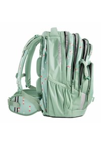 Mint green backpack featuring multiple zippered compartments, mesh padding, and a pattern of small red and white dots.