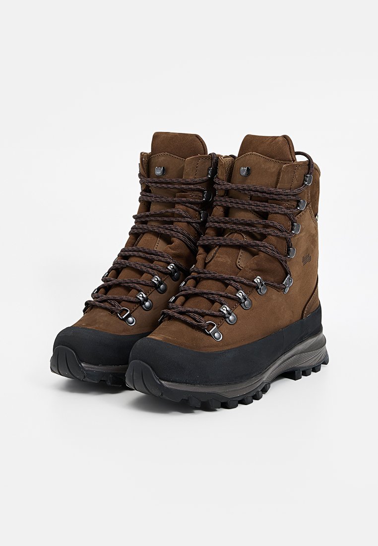 Braune Lederwanderstiefel mit schwarzen Gummisohlen und dunkelbraunen Schnürsenkeln, entworfen für unebenes Gelände und Knöchelunterstützung.