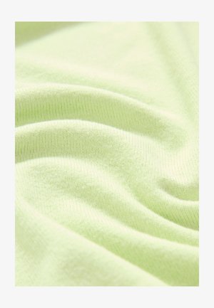 Világoszöld pamutanyag, sima felületű, enyhén gyűrött, finom kötésmintázattal, egyenletes szín- és puhaságeloszlással.