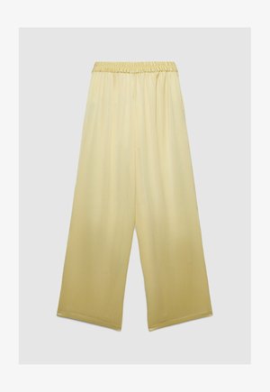 Loose-fitting, wide-leg, pale yellow pants with an elastic waistband, made from lightweight, textured fabric.