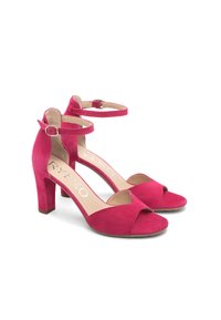 Różowe zamszowe sandały na wysokim obcasie z odkrytymi palcami, paskiem na kostkę i kwadratowym obcasem, charakteryzujące się gładką teksturą i ażurowym wzorem.