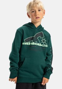 Zielona bluza z kapturem z miękkiego materiału. Posiada dużą grafikę w jasnej zieleni, kieszeń z przodu oraz ściągacze przy mankietach. Czarne akcenty na rękawach.