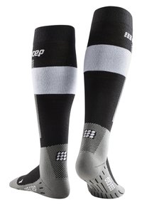 Calze a compressione in nero e grigio, con parte superiore a coste, strisce orizzontali e suole testurizzate con dettagli in gomma per una migliore aderenza.
