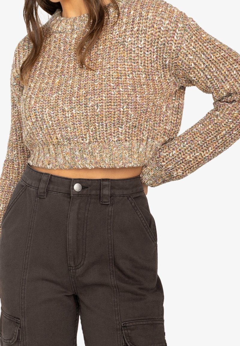 Pull court en maille crochetée, fibres multicolores ; col rond ; associé à un pantalon cargo noir taille haute avec fermeture à boutons.