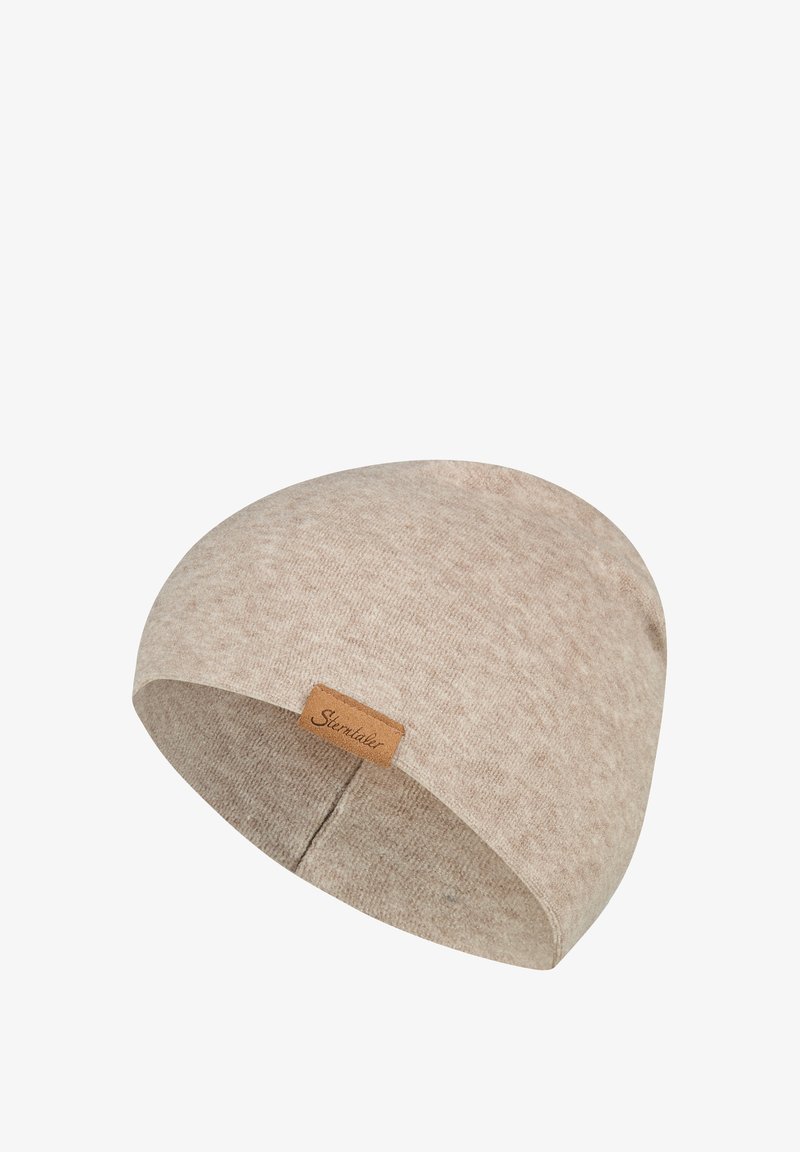 Beige knitted beanie hat with a small brown leather tag labeled "Sterntaler" on the side.