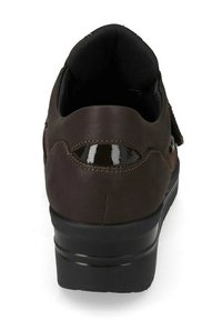 Scarpa di pelle marrone con interno imbottito nero, suola spessa nera e un dettaglio lucido curvo sul tallone, vista da dietro.