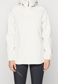 Veste légère blanche avec capuche, poignets élastiques et fermeture éclair devant. Présente un design simple et une texture lisse, adaptée à un usage décontracté.