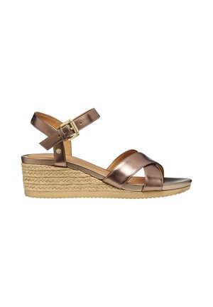 Bronzefarvet metallic kilehæl sandal med flettet jute platform, ankelrem og guldbeklædt spænde, vist fra siden på en hvid baggrund.