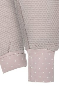 Rosa strukturierter Stoff mit einem Wabenmuster; Bündchen in einem einheitlichen Rosa mit weißen Punkten. Detaillierte Nähte an Kanten und Nähten.