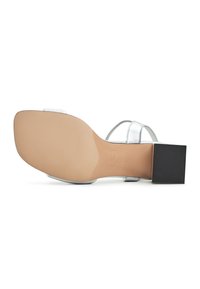 Hopea sandaali neliömäisellä korkolla. Pohjassa on sileä beige pinta ja kärjessä teksturoitu musta yksityiskohta.