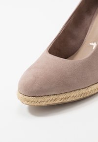 Espadrille in suede rosa chiaro con punta arrotondata, dettagli in corda di juta attorno alla suola e fodera interna liscia.
