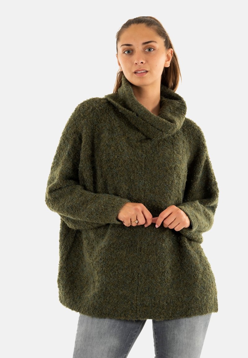 Groene textuur cowl-neck trui met een losse fit, lange mouwen en een zachte afwerking. Gepaard met lichtgrijze slim-fit jeans.