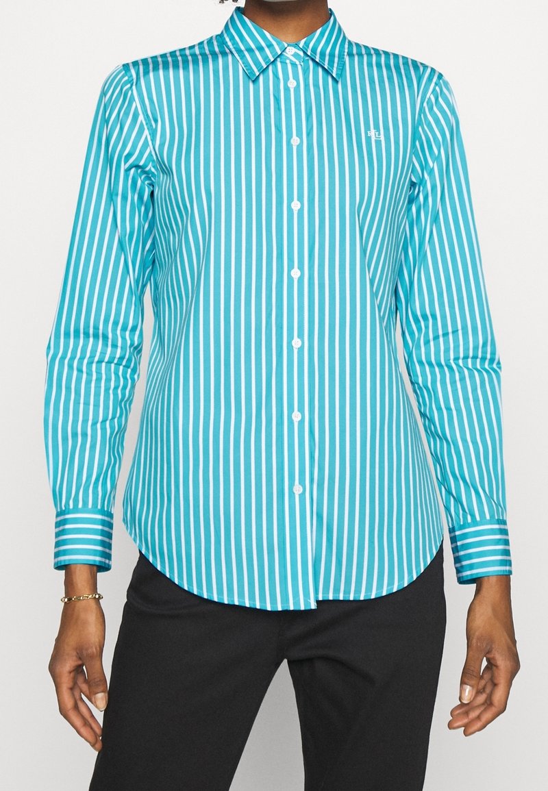 Turkos knapp-up skjorta med vertikala vita ränder, långa ärmar, en spetsig krage och en rundad nederkant med kontrasterande manschett-ränder.