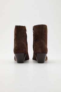 Hnědé semišové kotníkové boty s úzkým podpatkem, které mají boční zipy a hladký povrch. Design je jednoduchý a čistý, bez vzorů.
