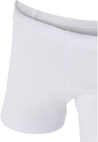 Tissu blanc côtelé en gros plan montrant la ceinture sans couture du sous-vêtement et les détails des coutures sur un matériau doux et extensible.