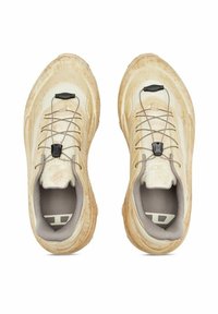 Scarpe sportive beige con parte superiore texturizzata, design leggero, lacci elastici e suola ammortizzata. Dettaglio nero evidente nel sistema di allacciatura.