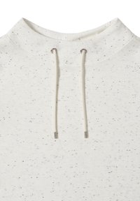 Vit sweatshirt med prickigt svart mönster, med dragkedja huva och metalliska detaljer på dragkedjans ändar. Mjuk textur.