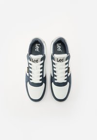 Zapatillas navy y blancas con una parte superior de cuero liso y ante, que cuentan con punta redonda, cordones blancos, empeine perforado y logo en la lengua.