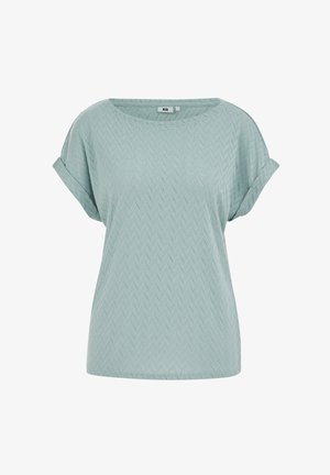 Jasnoniebieska bluzka z krótkim rękawem, o delikatnym wzorze koronki w kształcie jodełki i podwiniętych mankietach, z zaokrąglonym dekoltem.