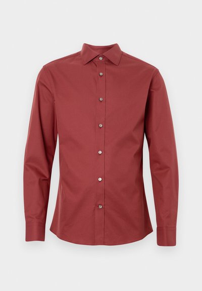 Dug dugotrajna košulja u tamnoj crvenoj boji, napravljena od pamuka, s prednjim zakopčavanjem na gumbe, oštrim ovratnikom i gumbu srebrne boje. Glatka tekstura.
