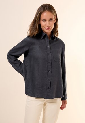 Donkergrijs button-up shirt van een gestructureerde stof. Beschikt over een klassieke kraag, een borstzak en lange mouwen.