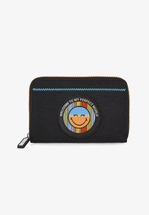Monedero de tela negra con un parche circular colorido que presenta una cara sonriente y el texto "BIENVENIDO A MI MUNDO PERFECTO". Cremallera y acentos naranjas.