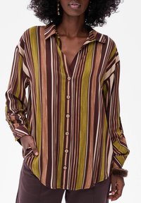 Striped button-up shirt in brown, green, and beige; features a v-neck, long sleeves, and wooden buttons; soft, lightweight fabric.