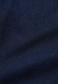 Tmavě modrý textil s hladkou strukturou, který se vyznačuje jemným leskem a subtilním vzorem tkaní, výrazně ukazuje hloubku a bohatost látky.