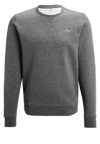 Grå sweatshirt gjord av mjukt tyg, med rund hals, långa ärmar, ribbade manschetter och en liten grön logotyp på bröstet.