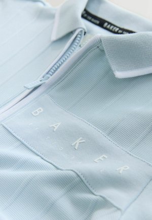 Gaiši zils ceturtdaļas rāvējslēdzēja polo krekls no teksturētas auduma ar vertikālām svītrām. Uz tā ir balts uzšuvums ar burtveidolu "BAKER".
