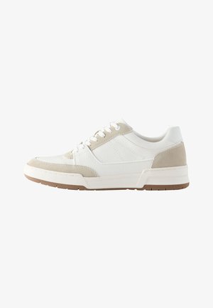 Zapatilla blanca de corte bajo con detalles en ante beige, cordones blancos, parte superior de cuero texturizado y suela de goma marrón sobre fondo blanco.