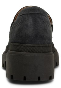 Svart mockaskor med en tjock, texturerad gummisula, med en slät bakdel och subtila sömnadsdetaljer. Designen betonar hållbarhet och stöd.