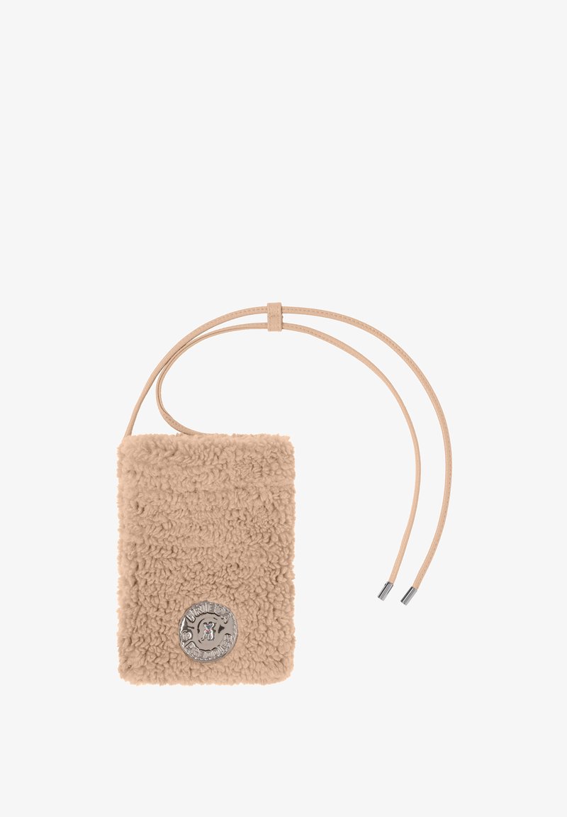 Beige schapenvacht schoudertas met verstelbare leren banden en een zilveren decoratief logo aan de voorkant. Zachte textuur en rechthoekige vorm.