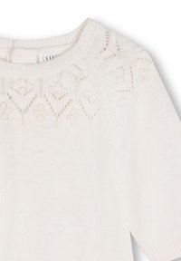 Maglione bianco a maglia con scollatura rotonda, caratterizzato da motivi floreali a traforo sulla spalla e da una texture soffice.